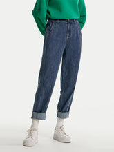 A lady wears a hoodie and jeans.